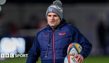 Scarlets defence coach Jared Payne carrying two rugby balls during a warm-up