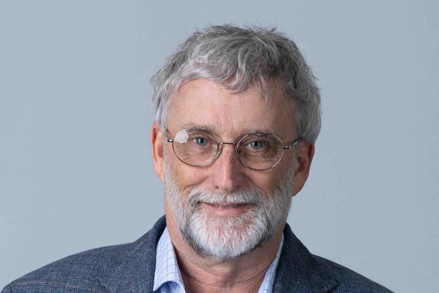 A man in a suit with a white beard and glasses