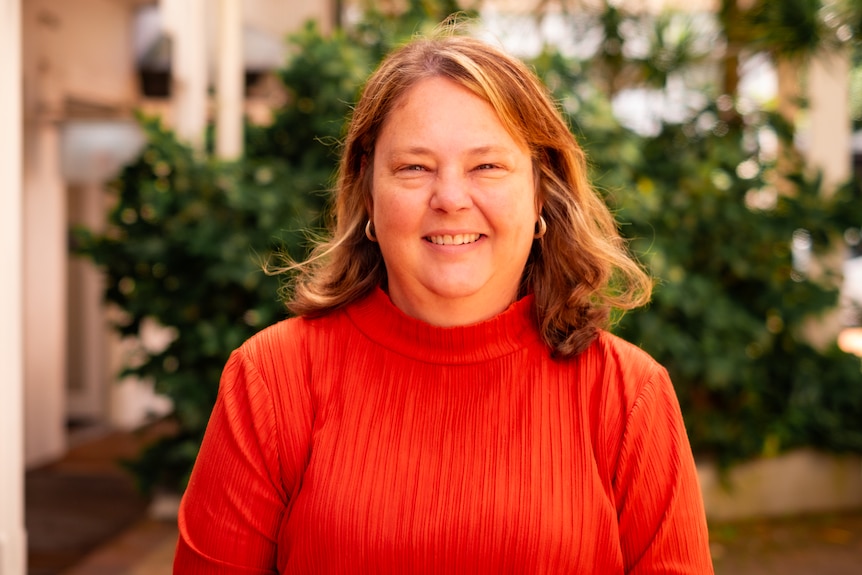 portrait of woman wearing bright red top.