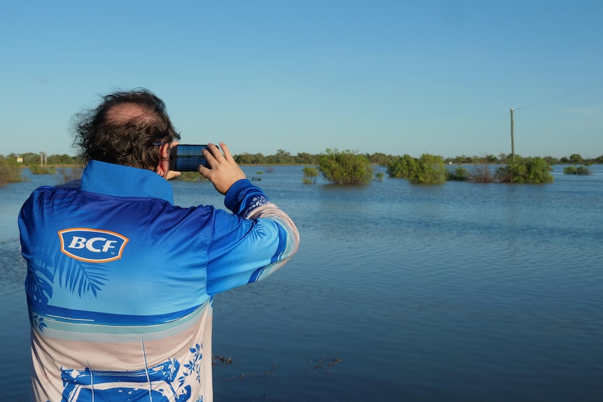 man taking photo of flood