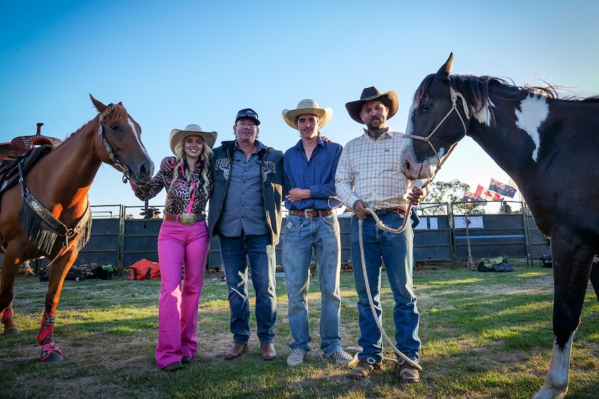 A family photo of four people and two horses