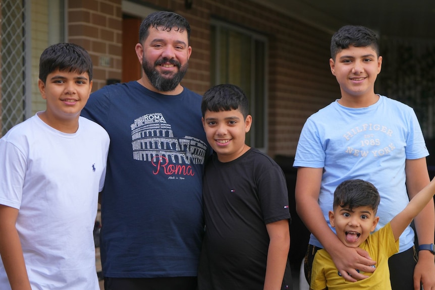 GHanim poses outside his brick home in western Sydney with his four sons. 
