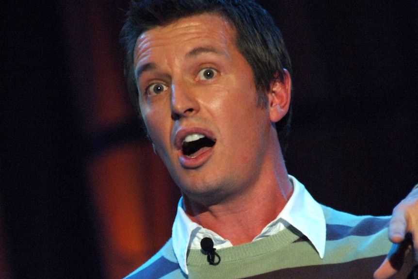 Rove mid speech on stage while pointing at something.