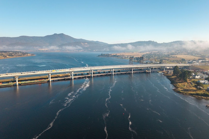 An aerial view of a new concrete bridge spanning a wide river