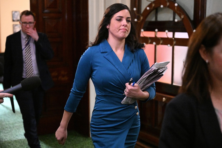 Moira Deeming walking with a folder in her hand.