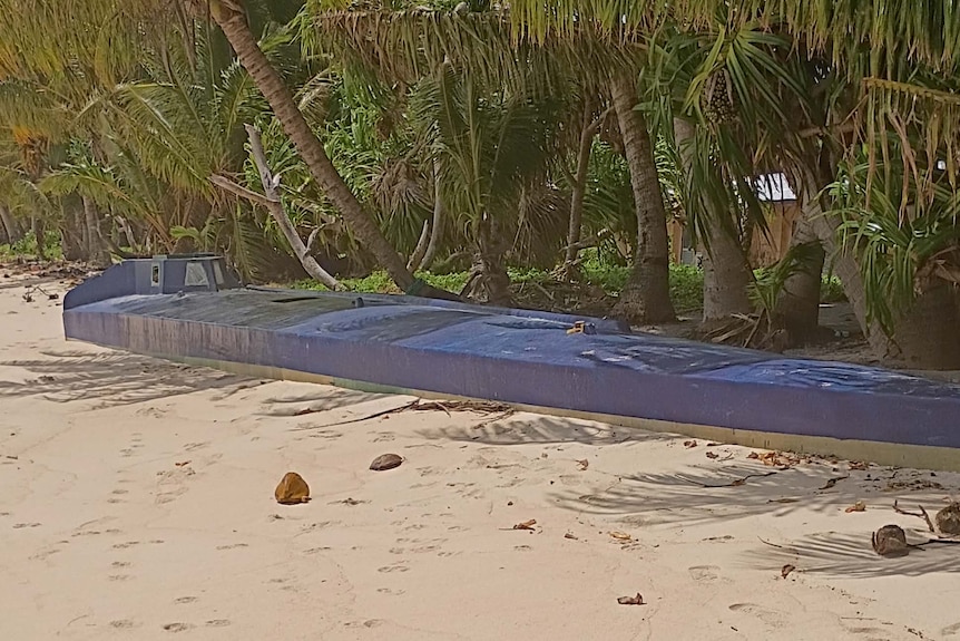 A long blue submarine on a beach 