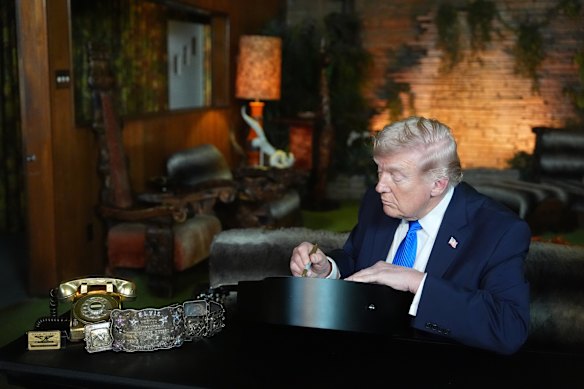 President Donald Trump signs a replica of a Elvis Presley guitar in the Jungle Room at Graceland.