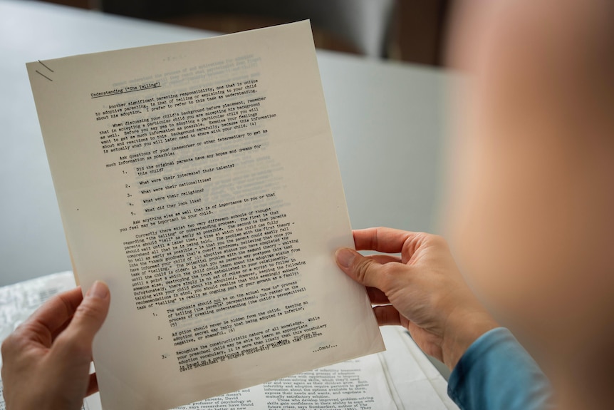Rose Mary holds up one of her adoption papers. 