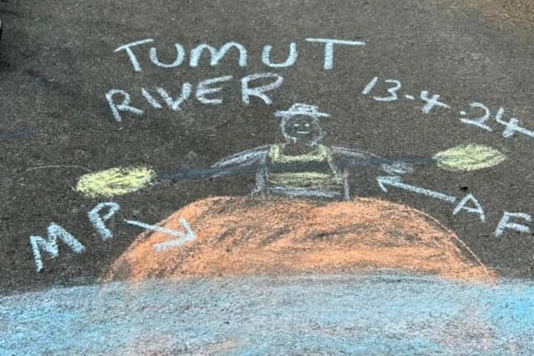 a chalk painting of a man riding a pumpkin in the river 