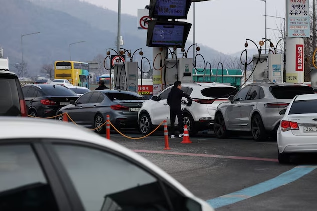 A man fills up his car at a gas station