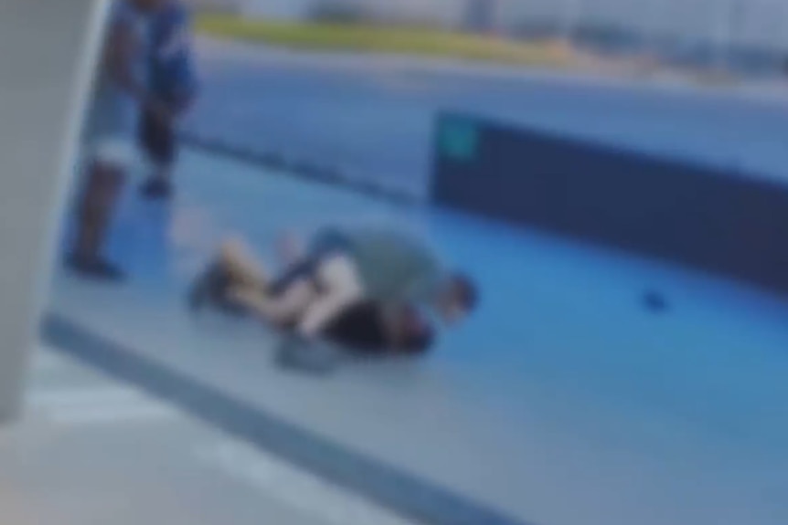 Two men struggling on the ground. 