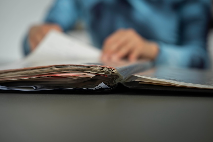 Rose Mary flicking through her adoption papers. 