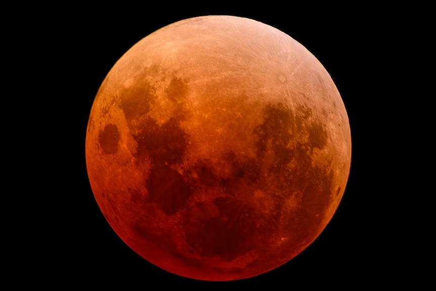 A red moon up close in the night sky