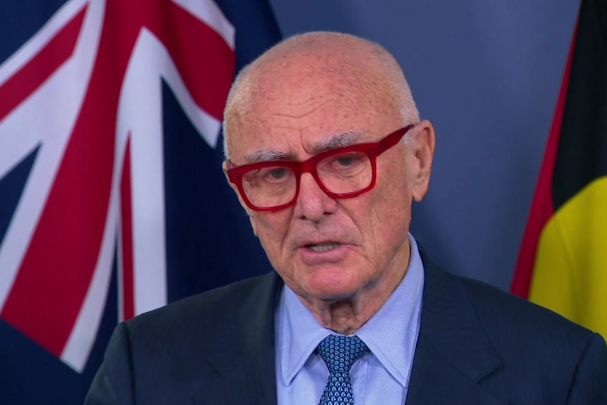 Man in red glasses and blue shirt.