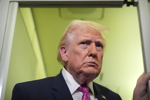 President Donald Trump speaks to reporters aboard Air Force One.