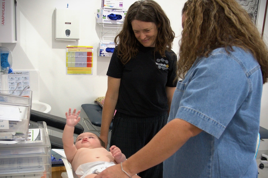 Midwife looks at baby