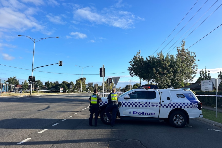 Police officers and a police vehicle.