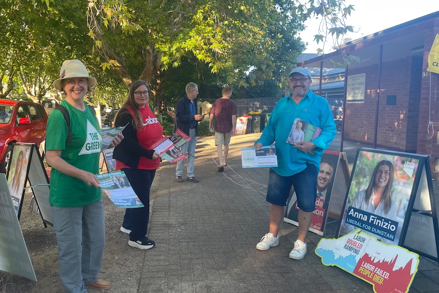 People wearing different colours handing out cards
