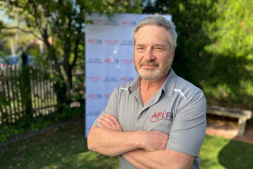 A man stands with his arms crossed.