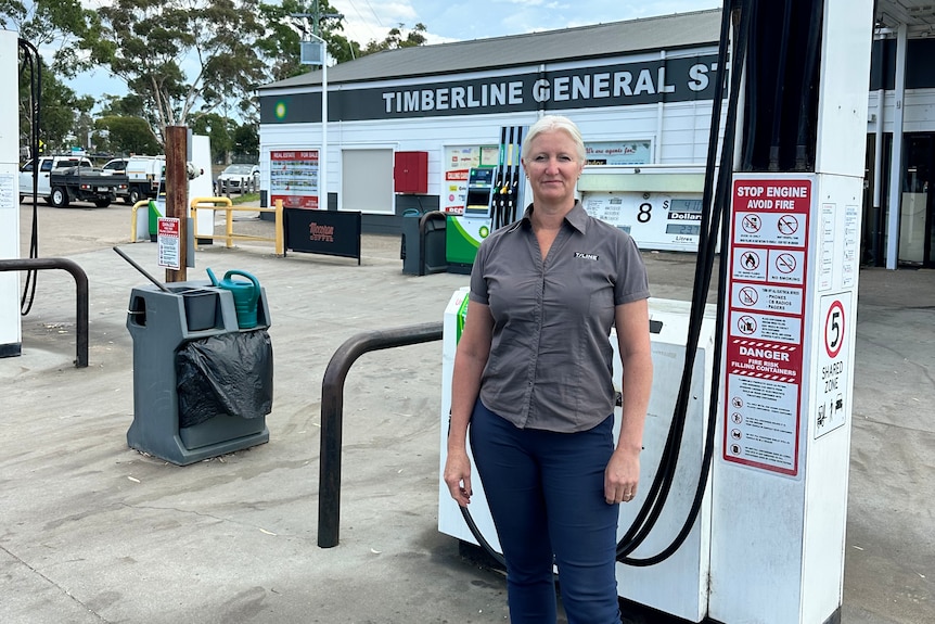 A woman standing in front of a petrol bowser