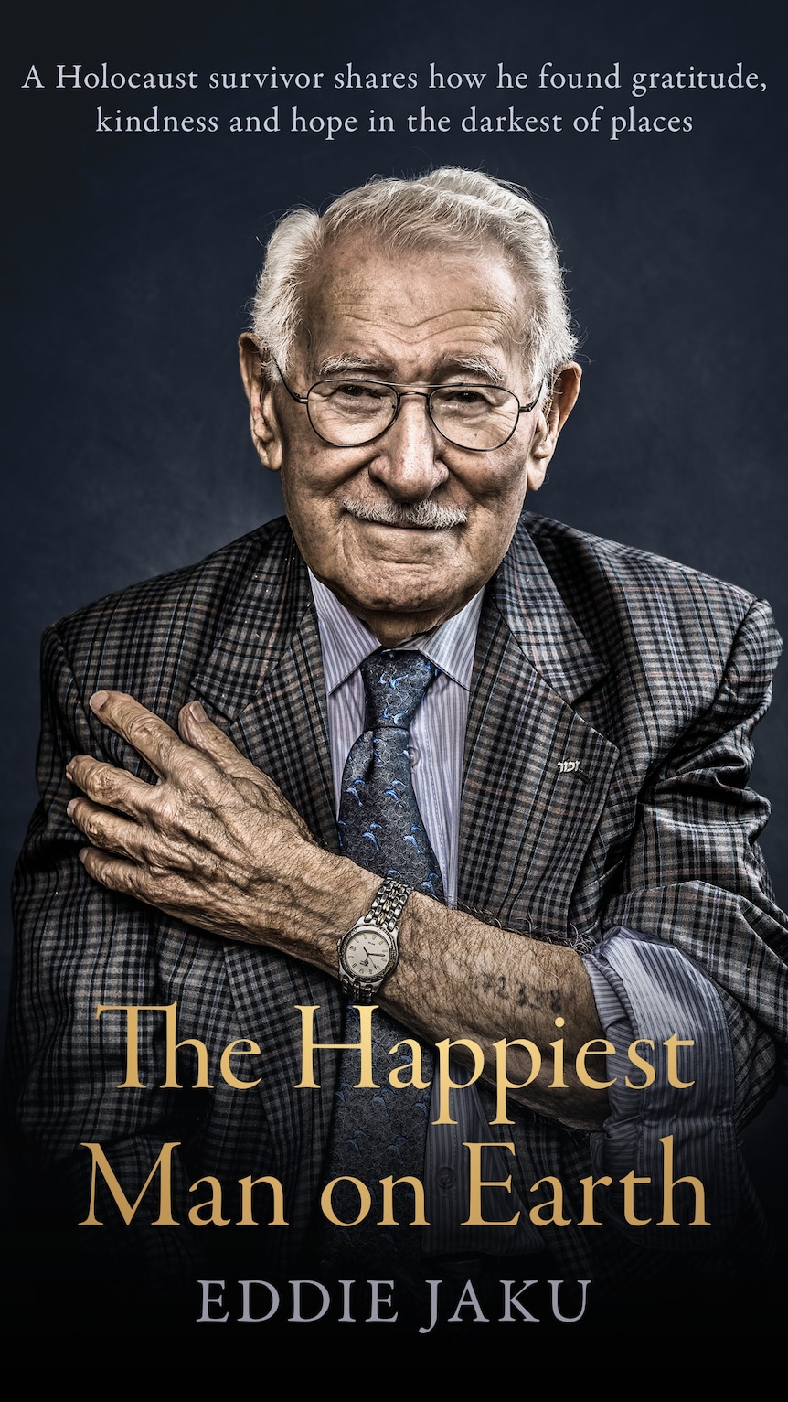 Book cover with title The Happiest Man on Earth, showing an older smiling man, exposing the tattoo on his forearm