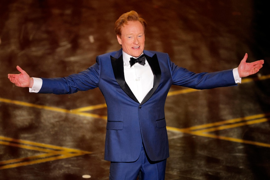 Conan O'Brien presents a speech on stage