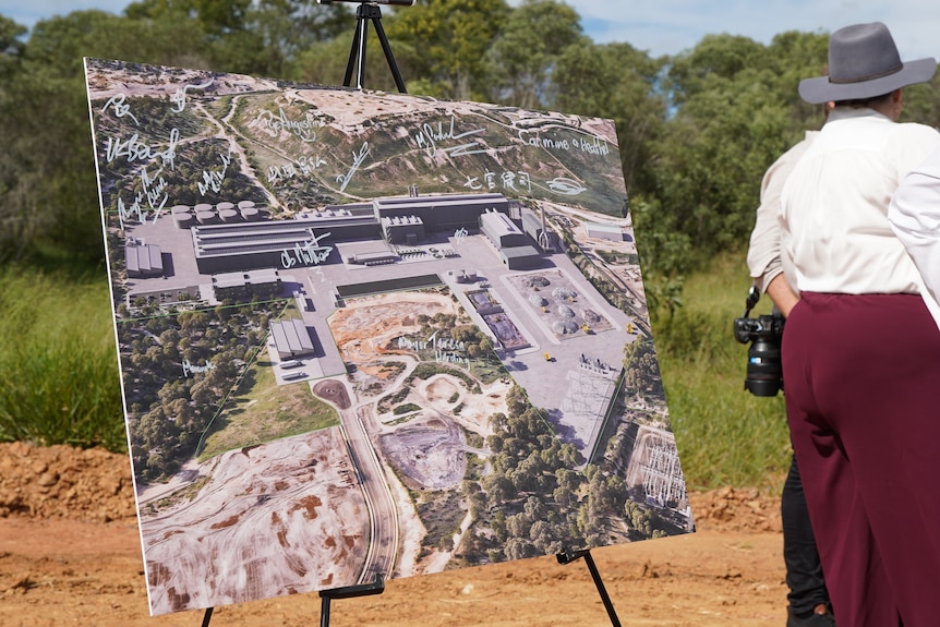 Artist impression of new steel mill set on a easel with bystanders in an open field.