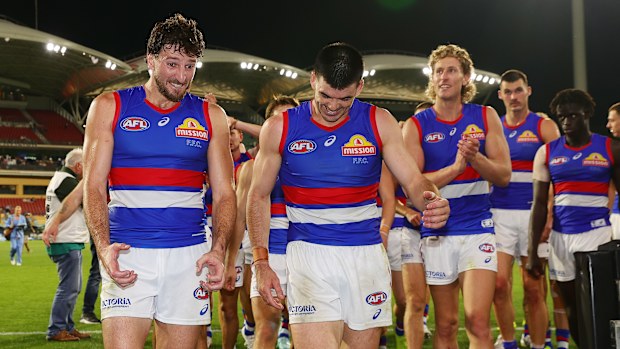 Marcus Bontempelli and Matthew Kennedy of the Bulldogs walk off the ground after a win.