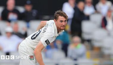 George Balderson, in whites wearing number 10 'BALDERSON', bowling for Lancashire at Old Trafford