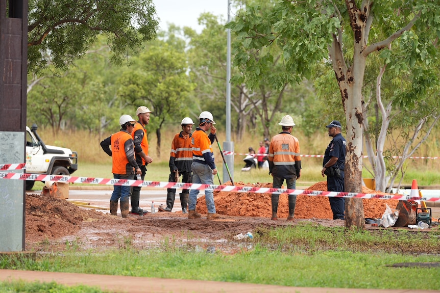 Workers in high vis dig a hole