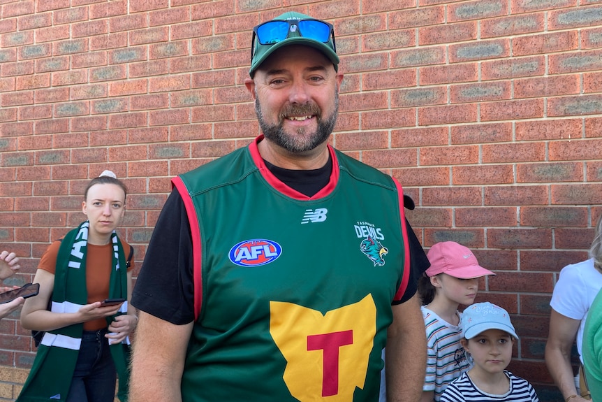 Football fans look at the camera.