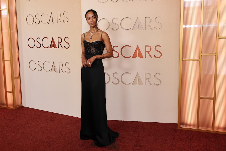 A woman in a lack gown with red necklace 