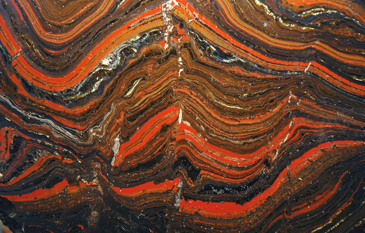 A series of ripples of orange and black are seen in an iron core
