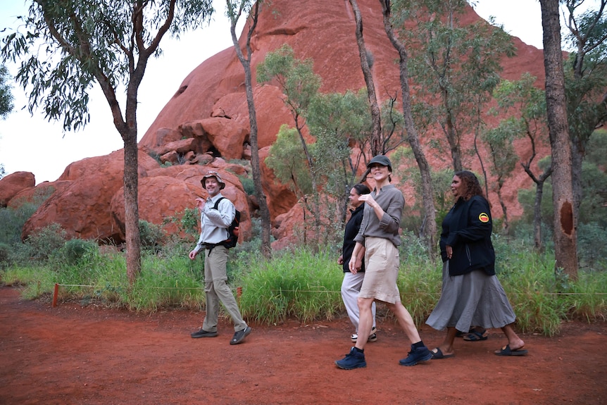 A couple walks through the desert with tour guides