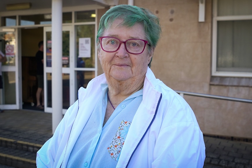 An elderly woman outside a voting booth