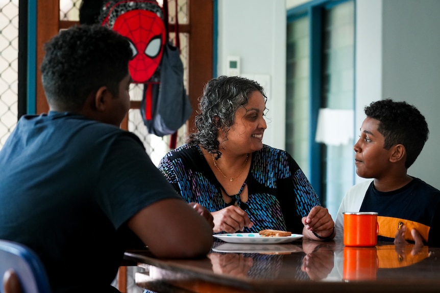 Gabbie sitting at a kitchen table with her two children