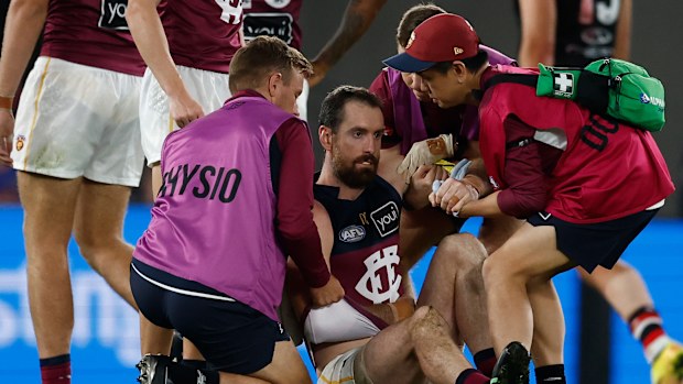 Darcy Gardiner of the Lions gets help from medical staff.