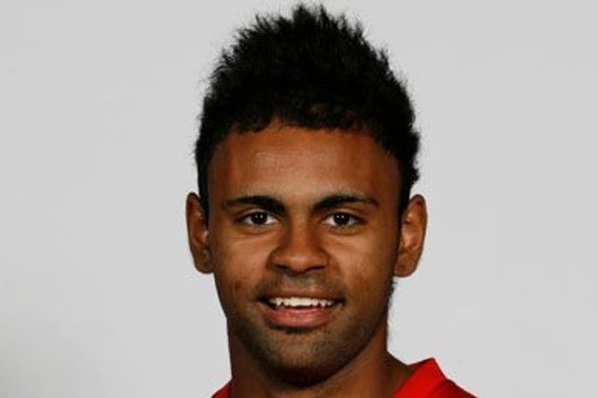 A headshot of an indigenous footballer smiling