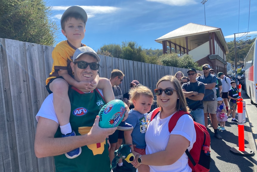 Football fans look at the camera.