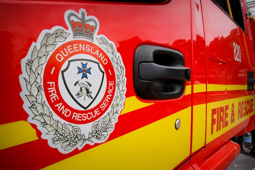 A close up of the Queensland Fire and Rescue Service logo on a red truck door. 