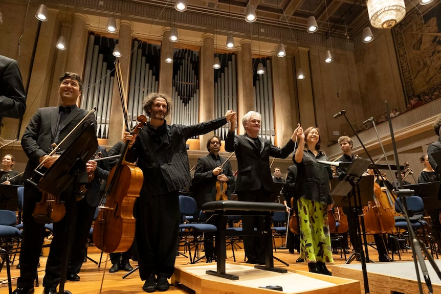The Bavarian Radio Symphony Orchestra, Nicholas Altstaedt, Liza Lim and their conductor stand to welcome applause.