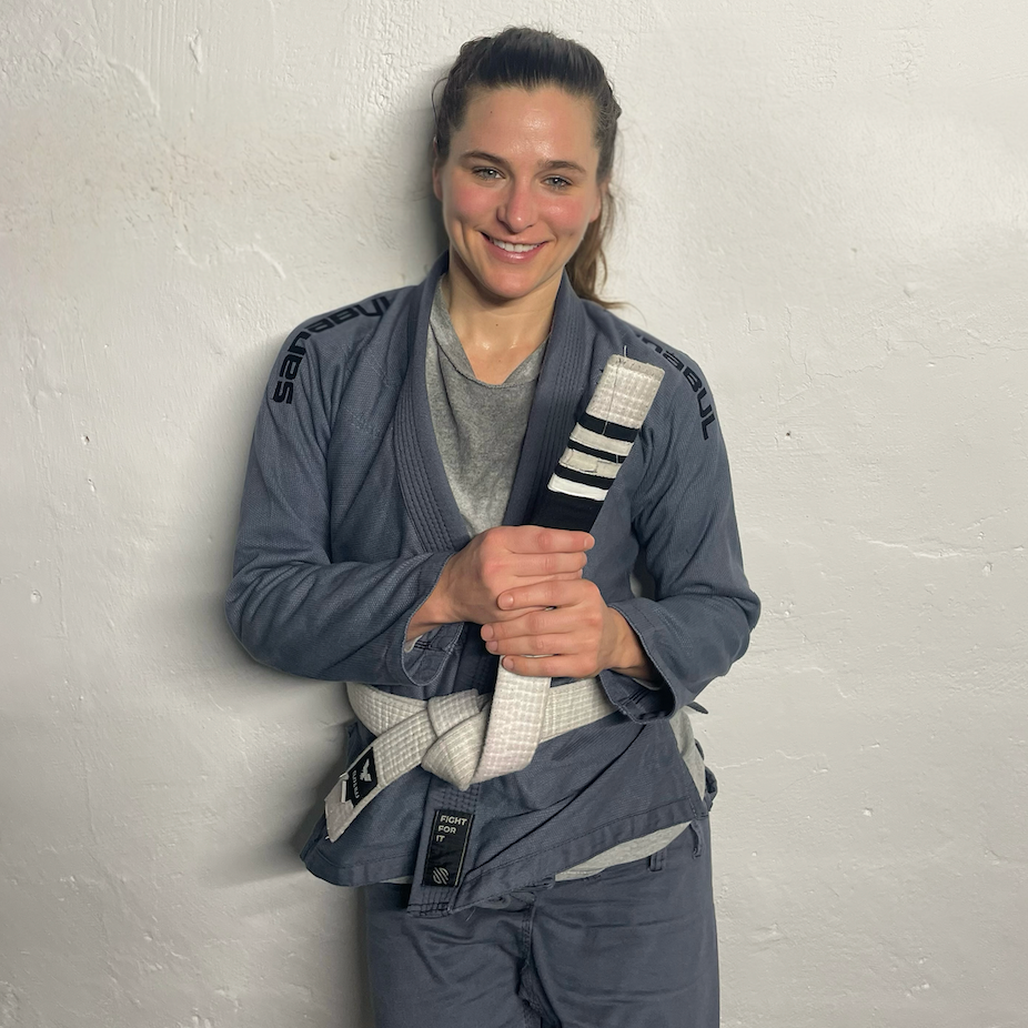 Person in martial arts uniform holding a training baton.