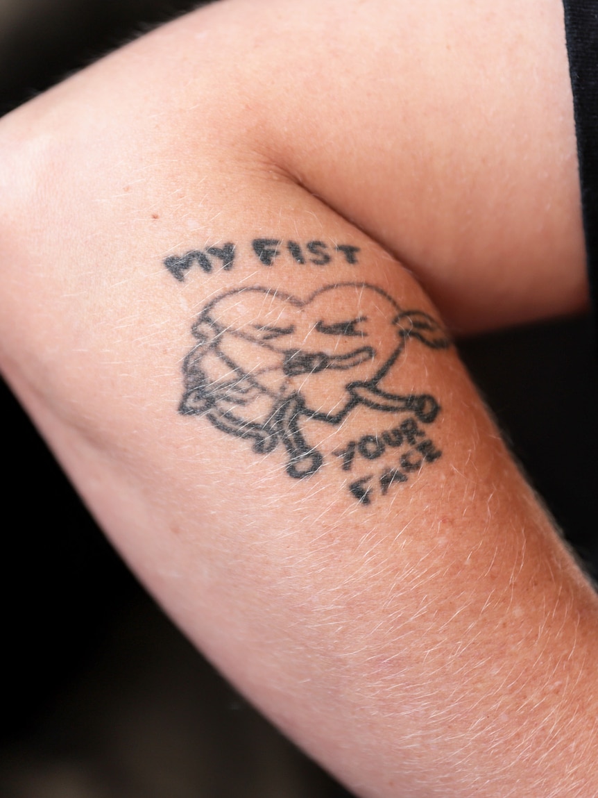 Tattoo on a woman's arm that reads My Fist Your Face