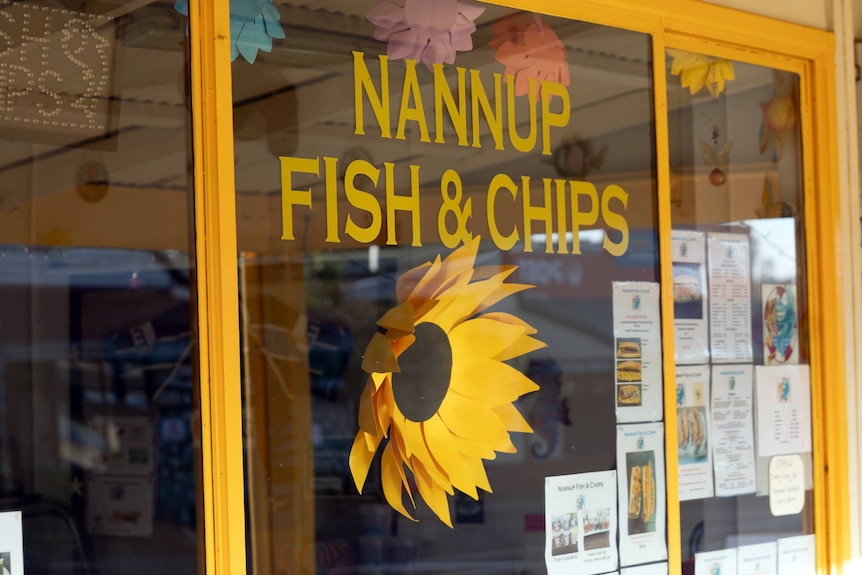 The front window of a fish and chip shop displaying a large daffodil motiff.