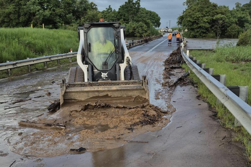 A dozer excavates mud from a roadway.