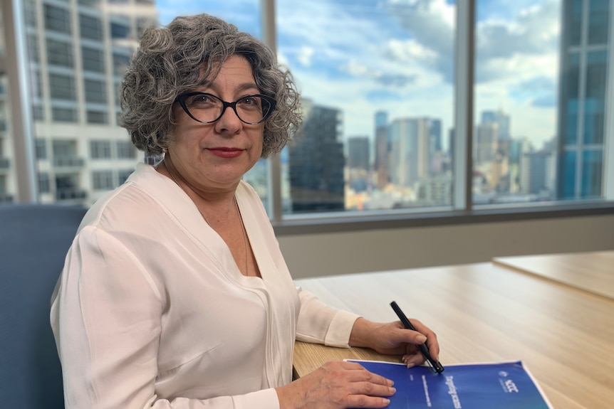 A middle-aged woman in spectacles in an office 