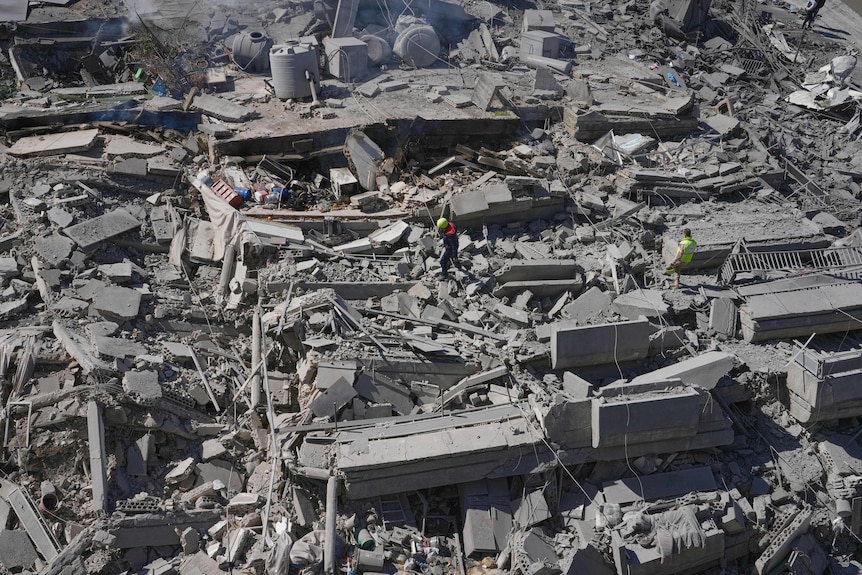 Rescue workers check a destroyed building that was hit by an Israeli airstrike in Nabatiyeh town, south Lebanon, Thursday