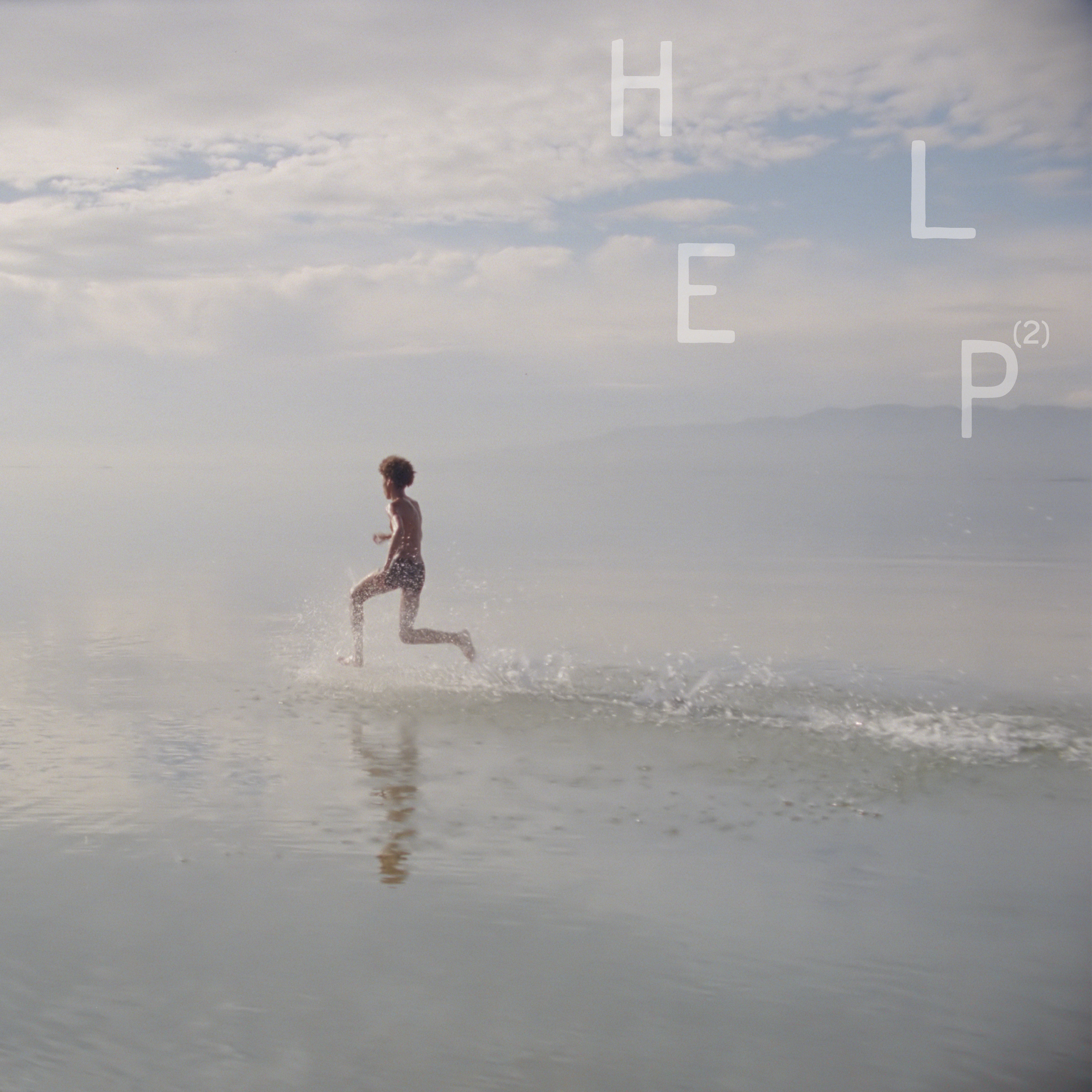 A person runs through shallow water beneath a soft, cloudy sky, with the word “HELP²” spaced across the image
