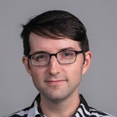 Jack Newsham's face on a gray background.