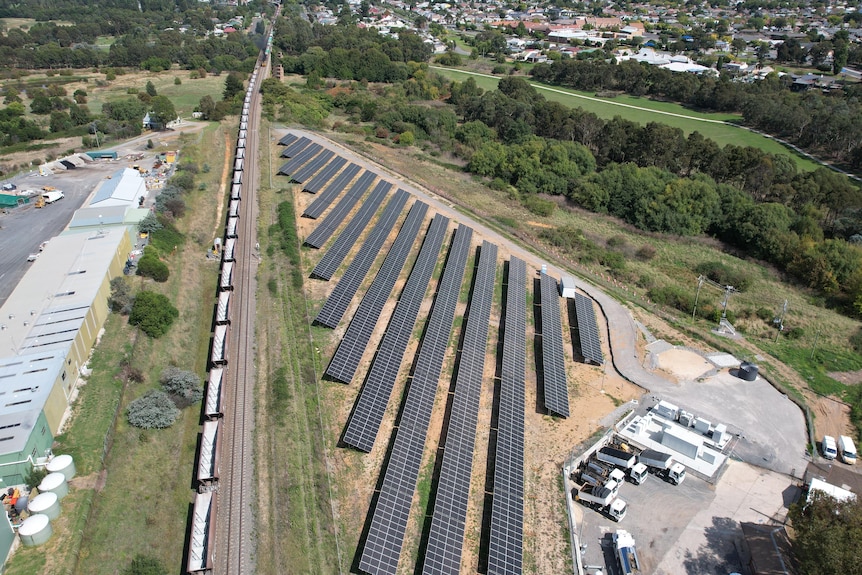 Aerial image of a rail line beside a solar farm